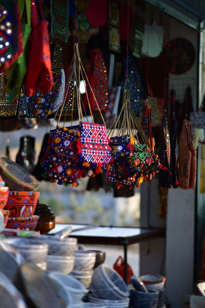 Vibrant display of handcrafted bags and pots in a traditional Pakistani market.
